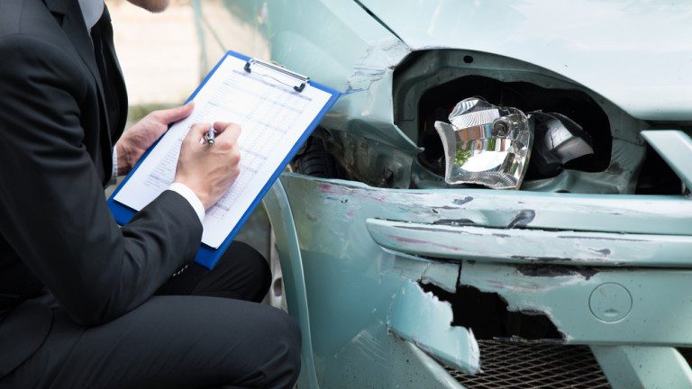 cropped insurance agent examining accident