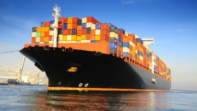 orange black loaded container ship harbour